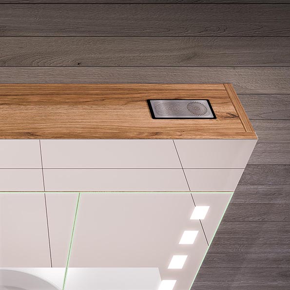 Unobtrusive speaker hidden behind a mirror